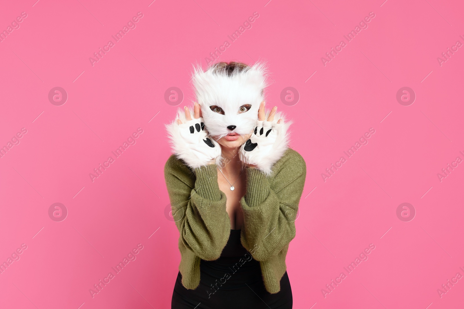 Photo of Quadrobics. Woman wearing cat mask and gloves on pink background