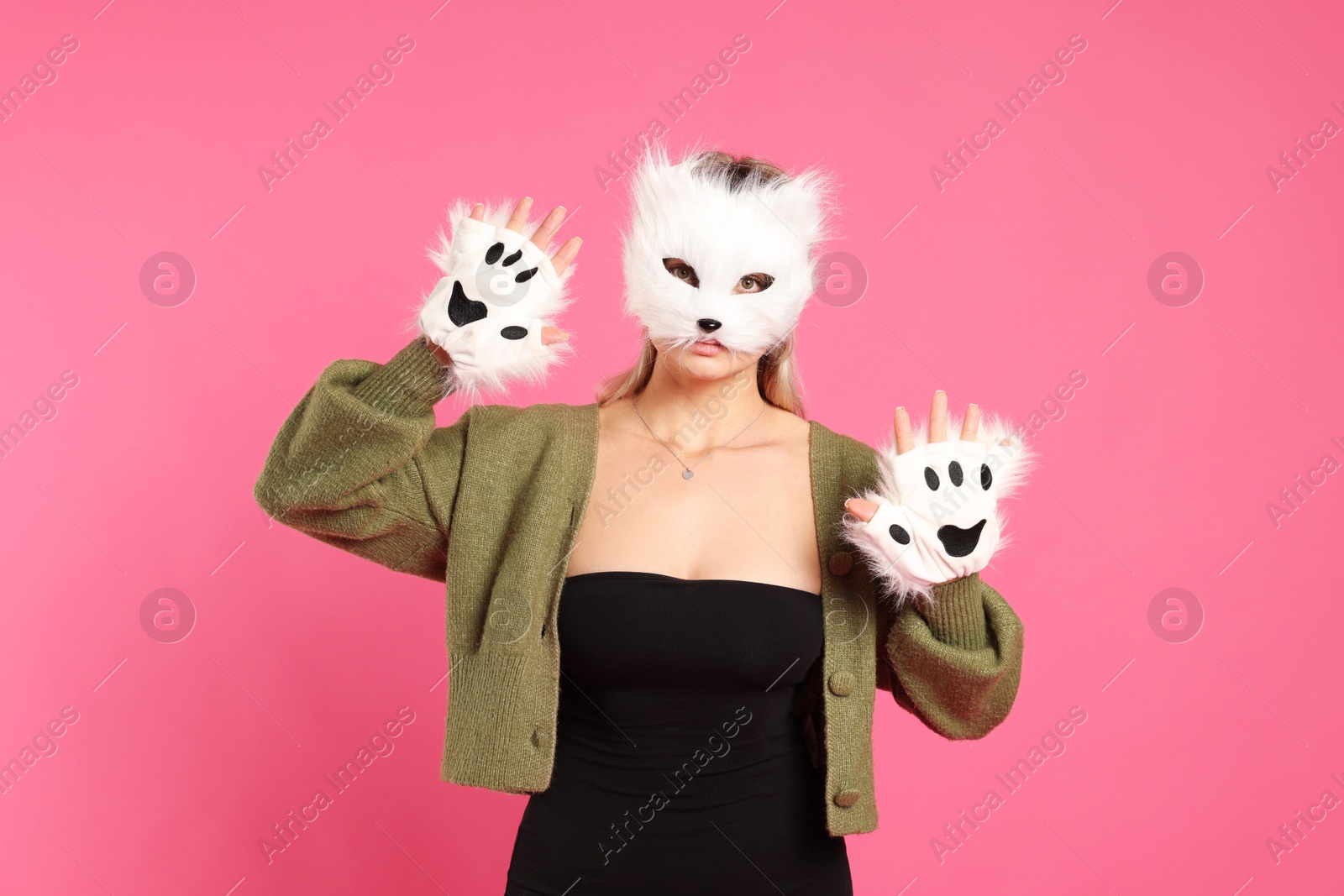 Photo of Quadrobics. Woman wearing cat mask and gloves on pink background