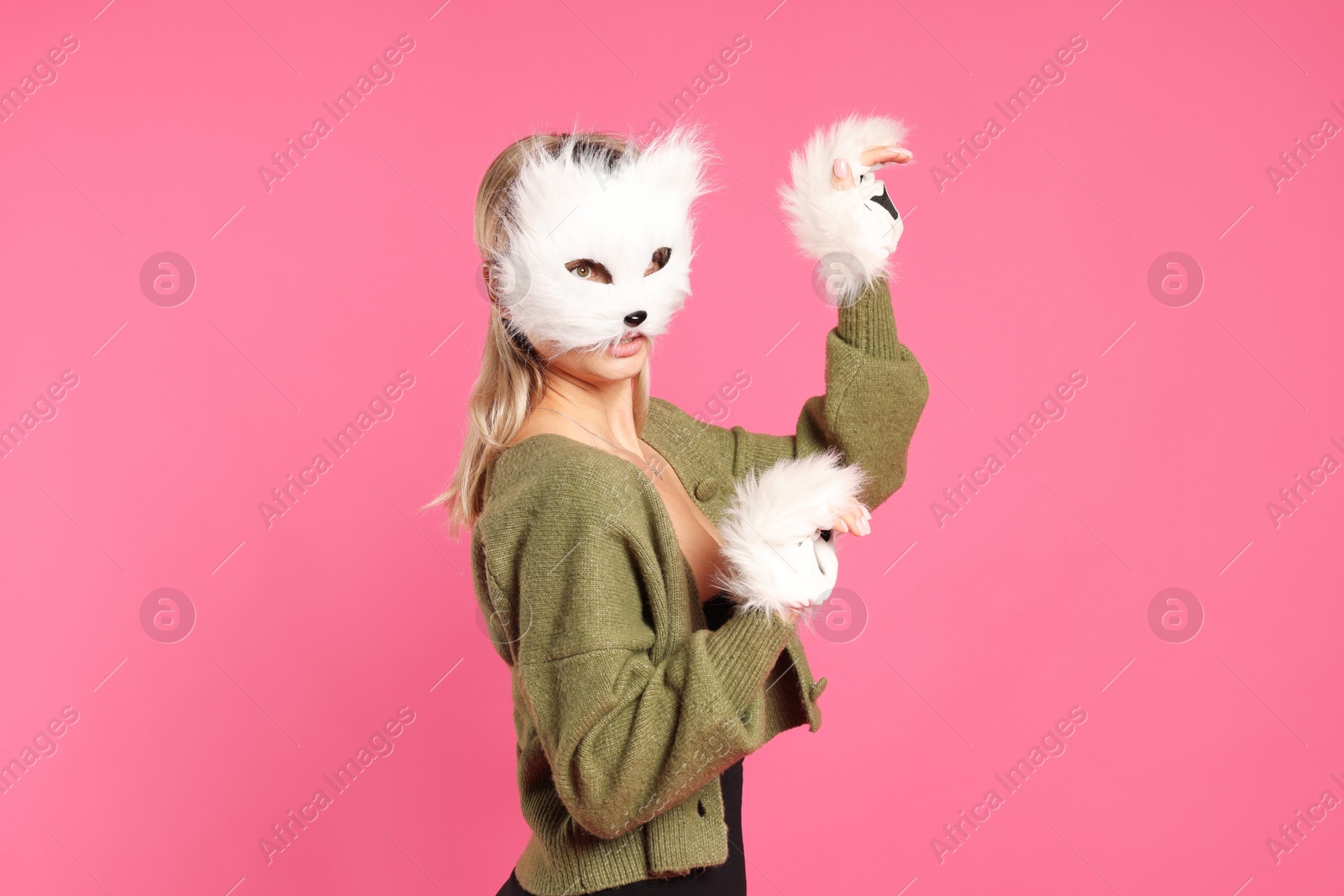 Photo of Quadrobics. Woman wearing cat mask and gloves on pink background