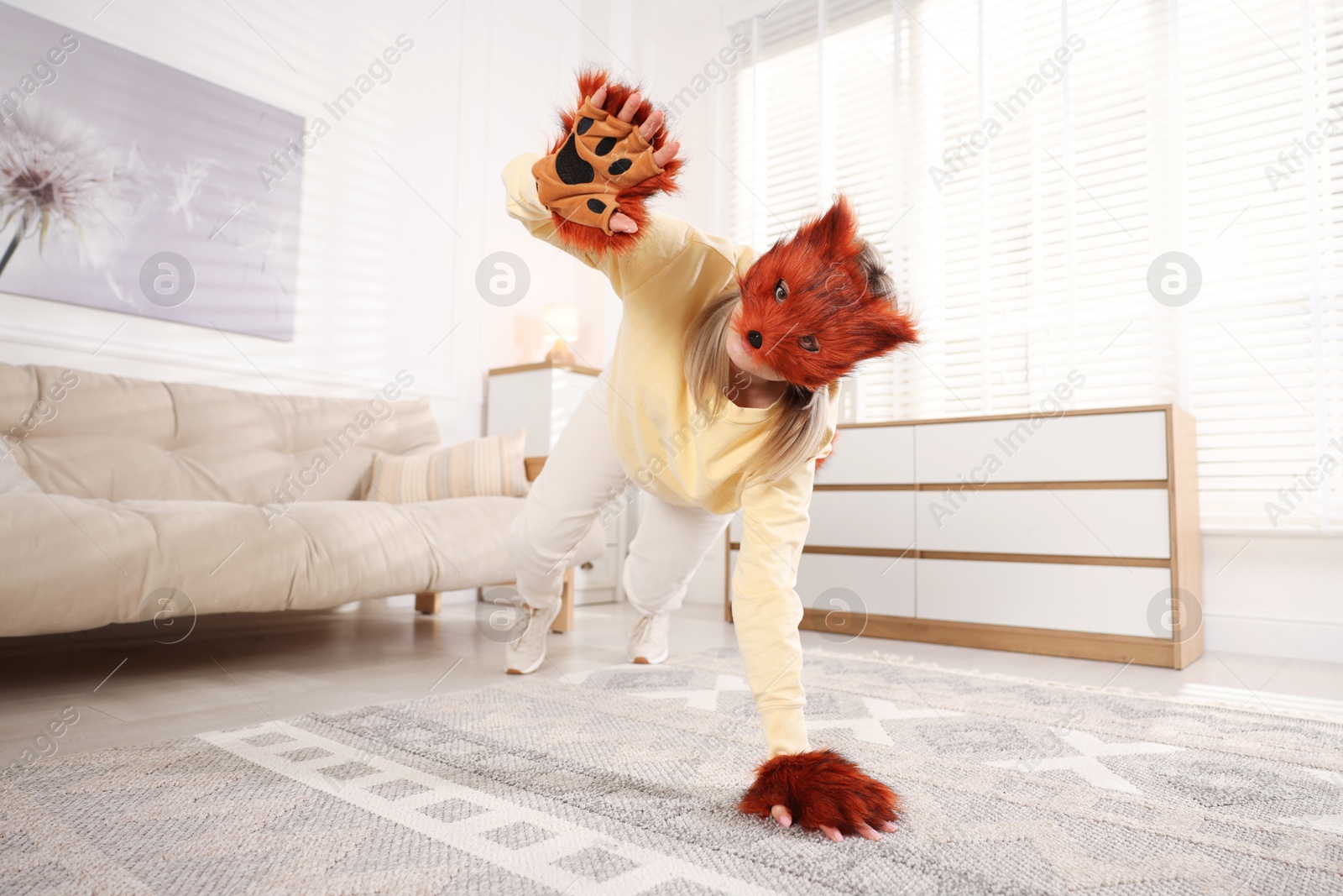 Photo of Quadrobics. Woman wearing fox mask and gloves at home