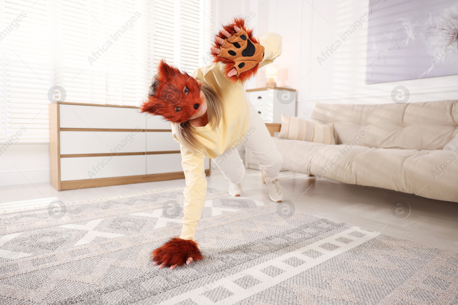 Photo of Quadrobics. Woman wearing fox mask and gloves at home