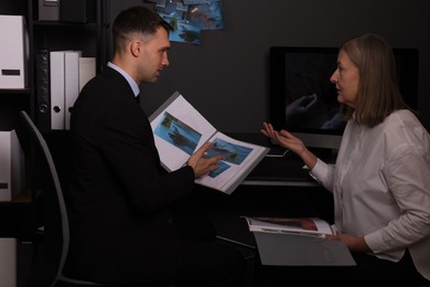 Photo of Forensic experts working with crime scene photos in office