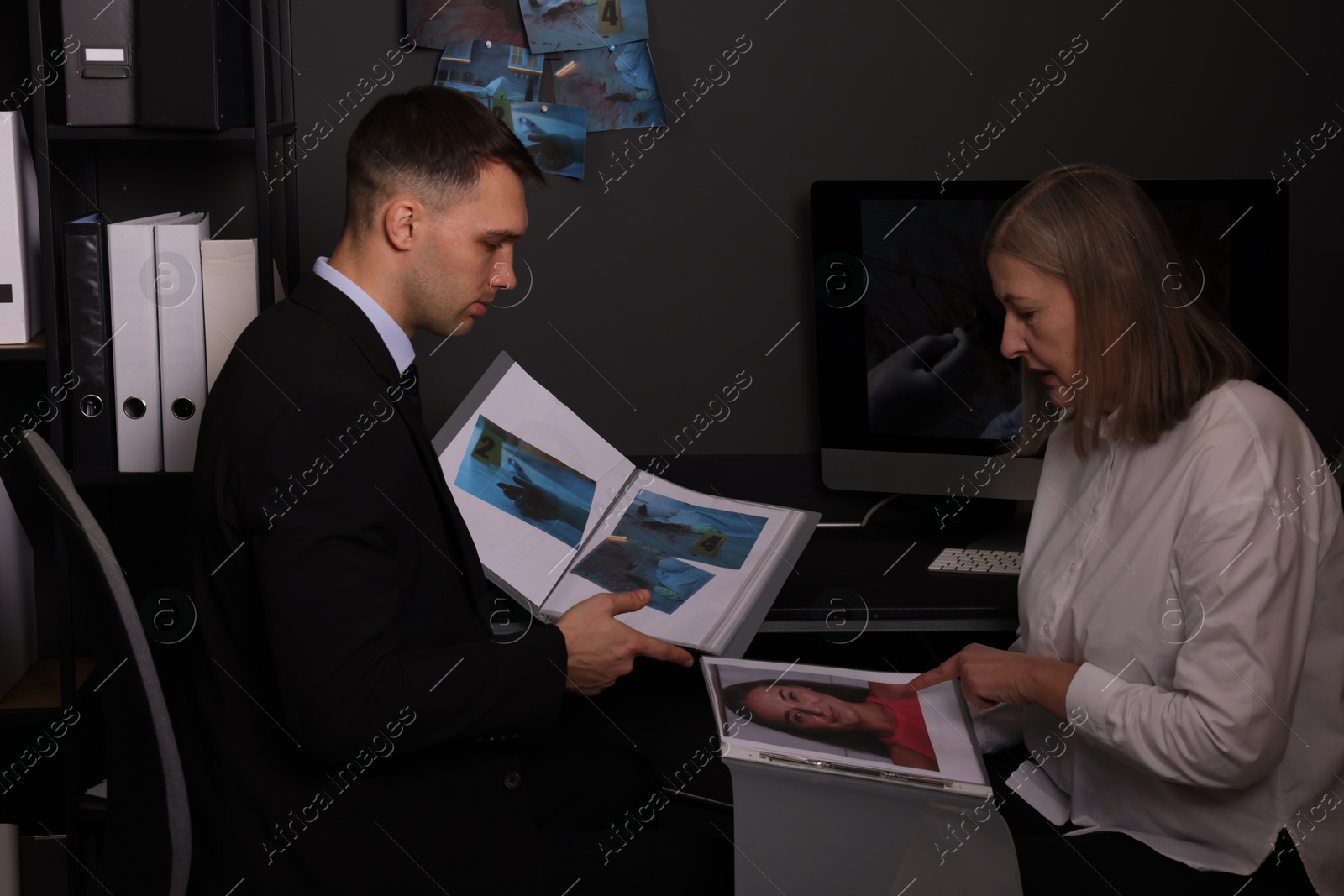 Photo of Forensic experts working with crime scene photos in office