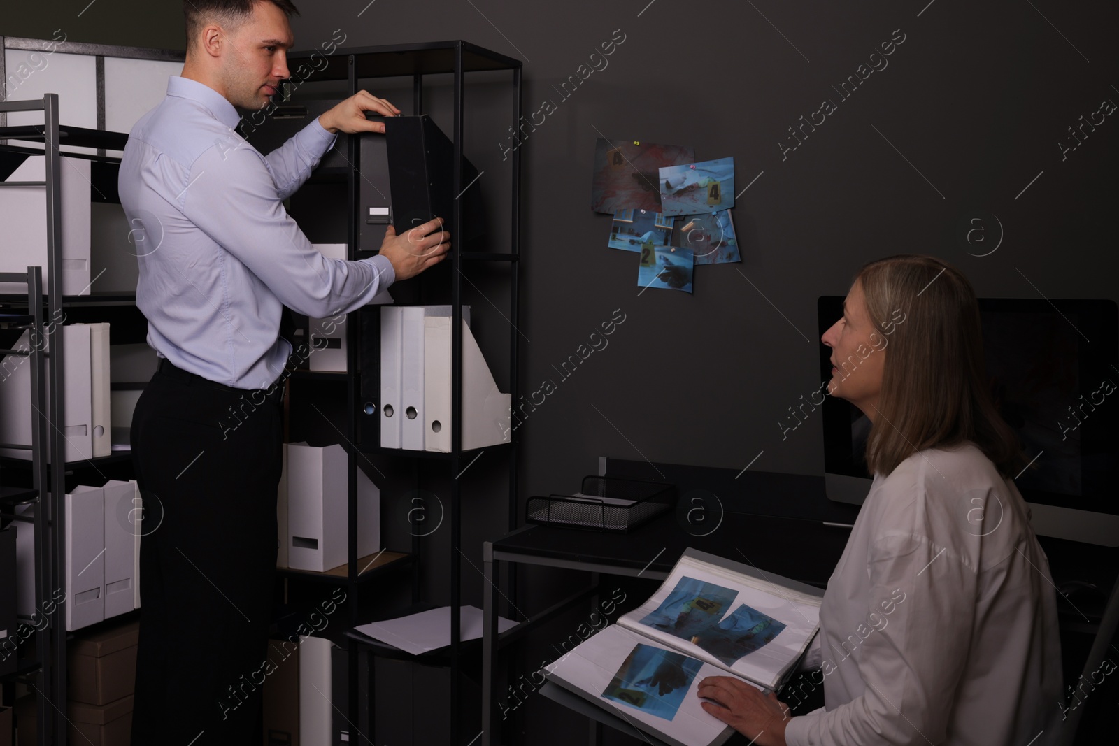 Photo of Forensic experts working with crime scene photos in office