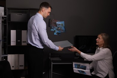 Photo of Forensic experts working with crime scene photos in office