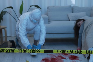 Forensic expert working at crime scene with dead woman's body indoors, selective focus