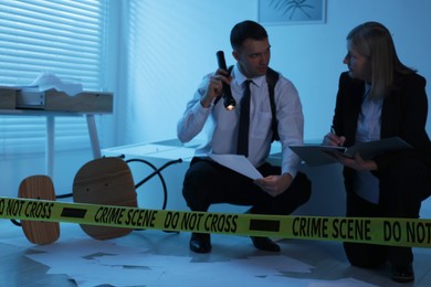 Forensic experts working at crime scene indoors, selective focus