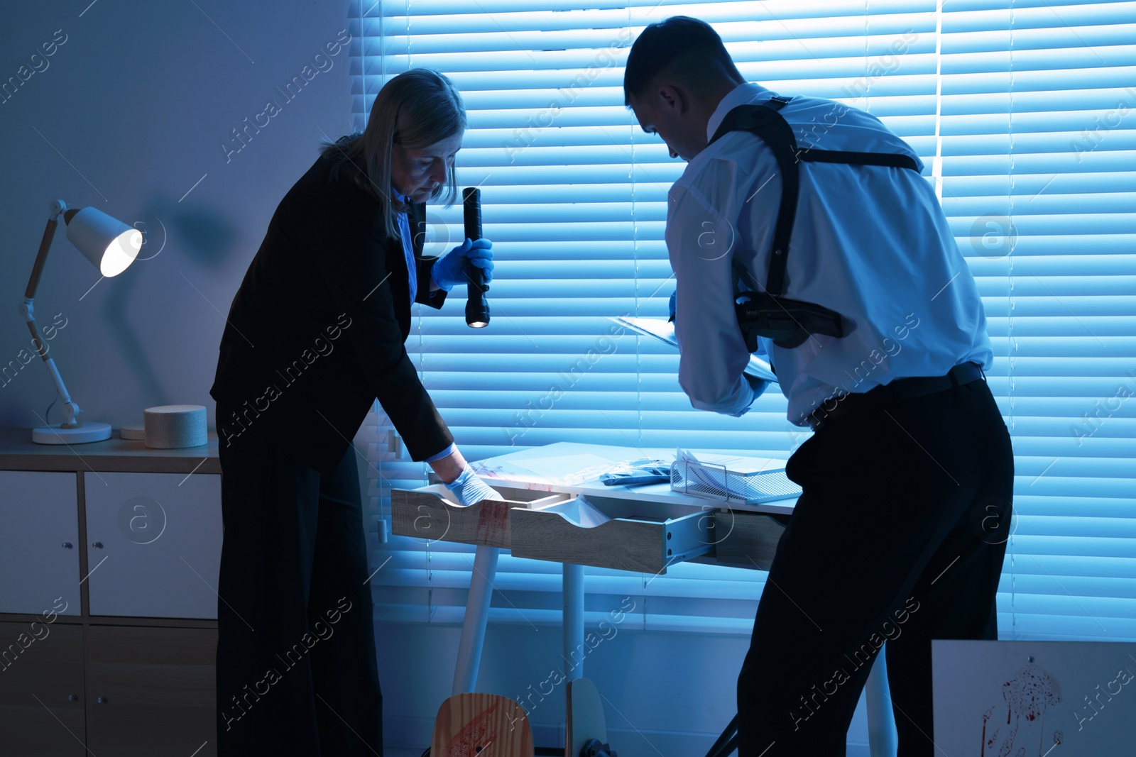 Photo of Forensic experts working at crime scene indoors