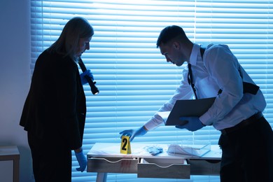 Forensic experts working at crime scene indoors