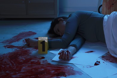 Photo of Crime scene with dead woman's body indoors