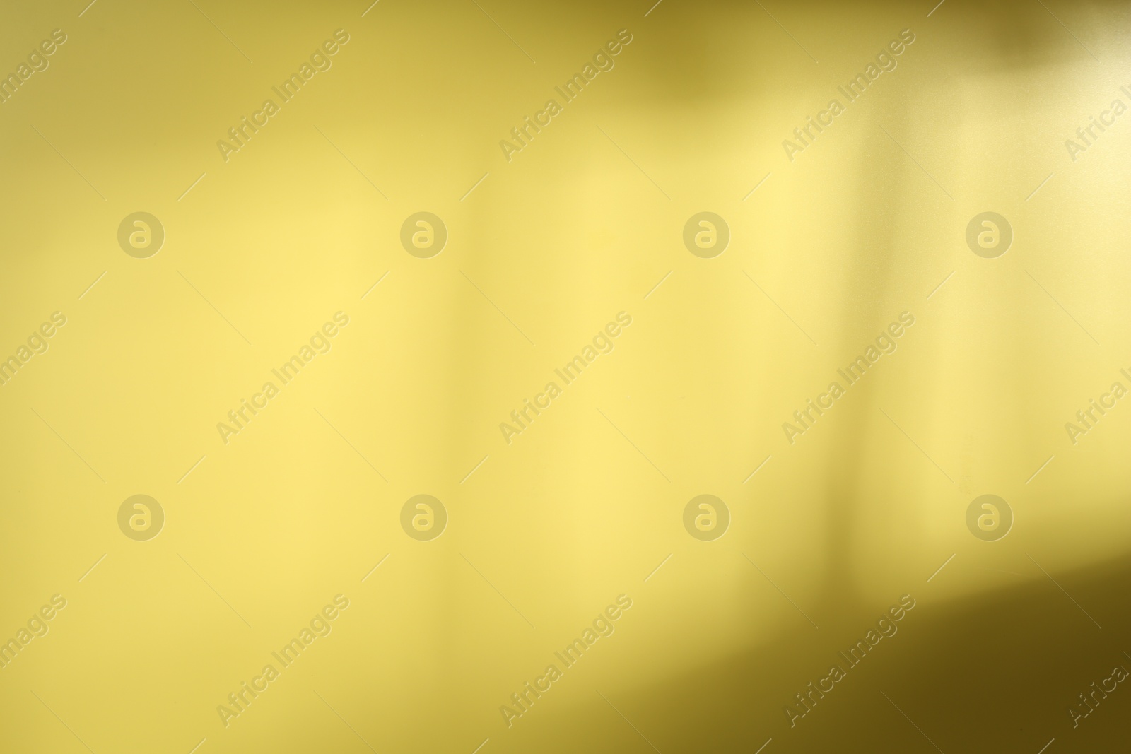 Photo of Light and shadow falling on yellow background