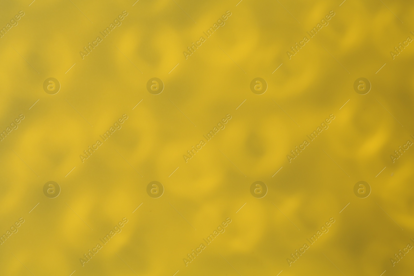 Photo of Light and shadow falling on dark yellow background