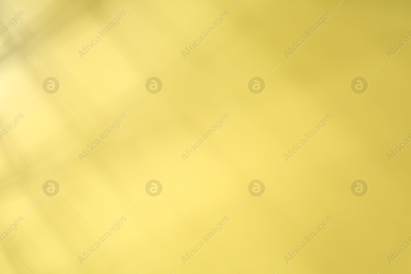 Photo of Light and shadow falling on yellow background