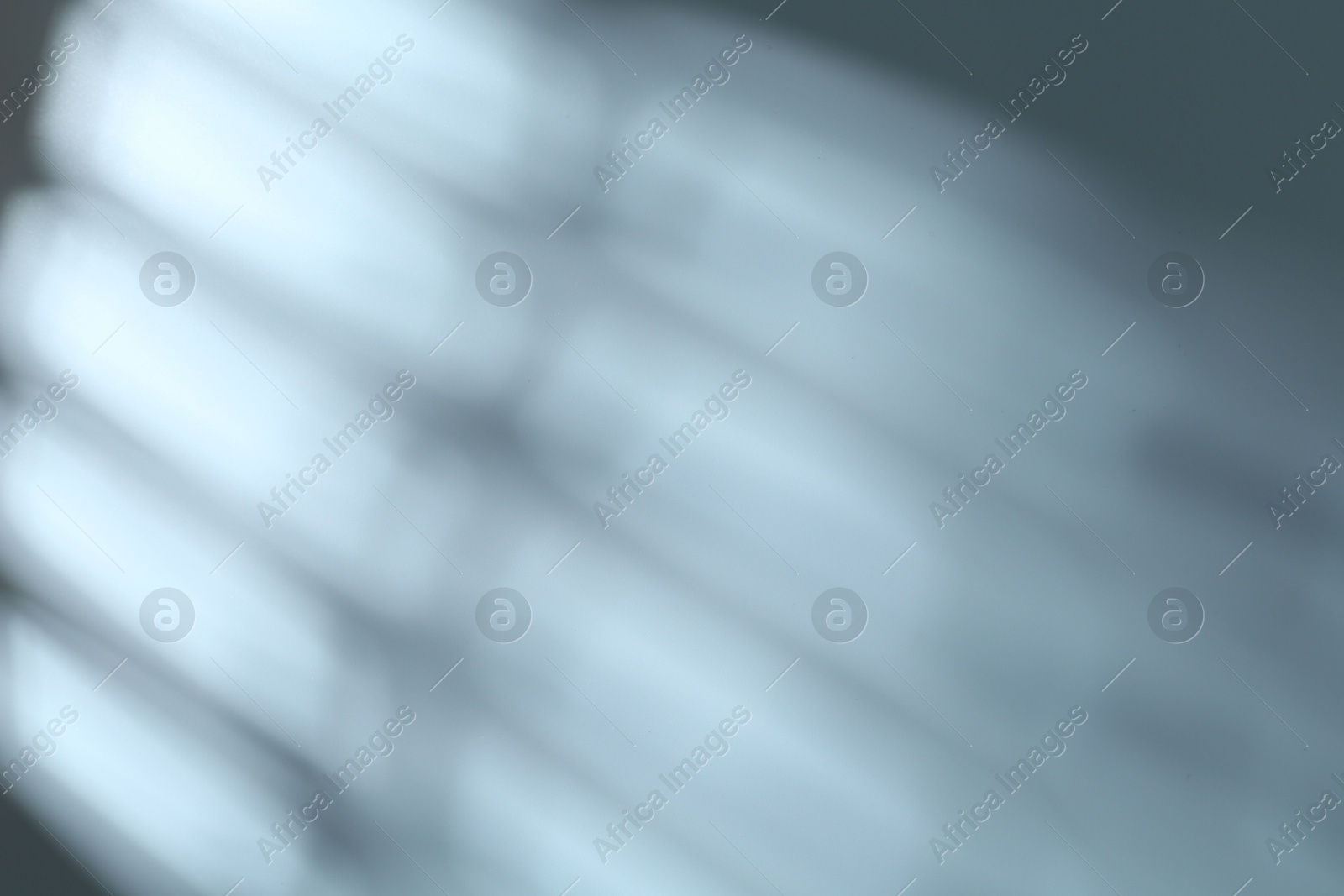 Photo of Light and shadows falling on grey background