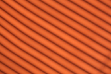 Photo of Light and shadows falling on orange background