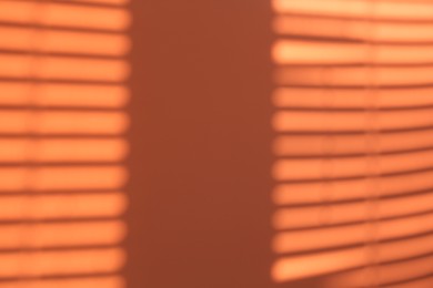 Photo of Light and shadows falling on orange background