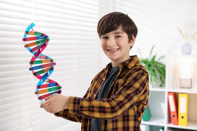 Photo of Smiling boy with DNA structure model indoors