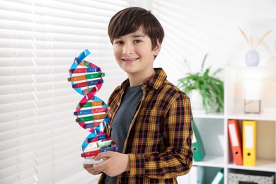 Photo of Smiling boy with DNA structure model indoors