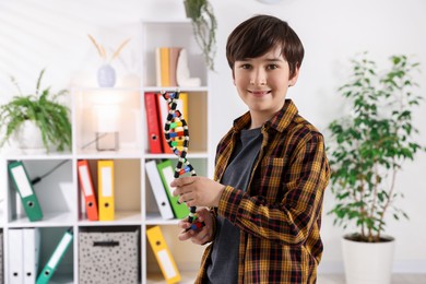 Photo of Smiling boy with DNA structure model indoors. Space for text