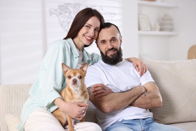 Happy daughter, father and dog on sofa at home