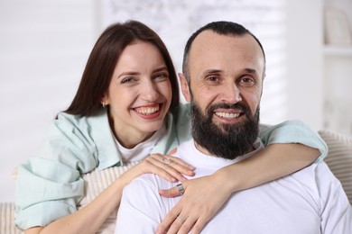 Photo of Portrait of happy daughter and father on sofa at home