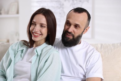 Happy daughter and father on sofa at home