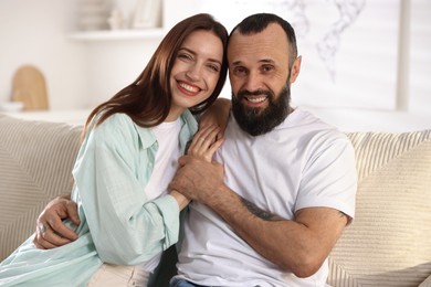 Portrait of happy daughter and father on sofa at home