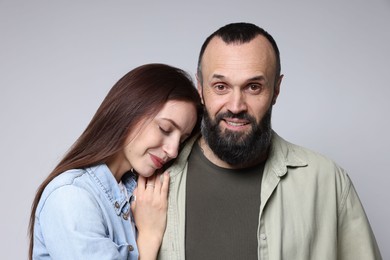 Photo of Happy daughter and father on light grey background