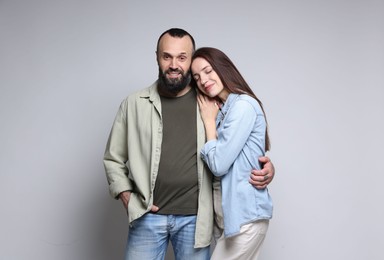 Photo of Happy daughter and father on light grey background