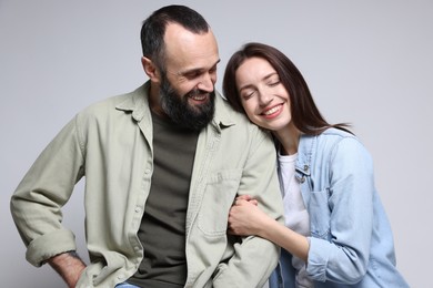 Photo of Happy daughter and father on light grey background