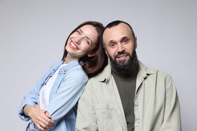 Portrait of happy daughter and father on light grey background