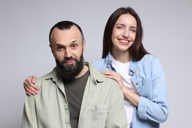 Portrait of happy daughter and father on light grey background