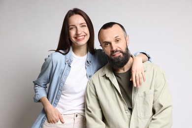 Portrait of happy daughter and father on light grey background