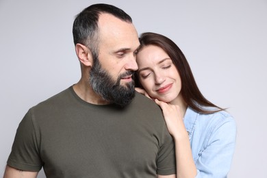 Happy daughter and father on light grey background