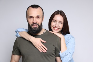 Portrait of happy daughter and father on light grey background