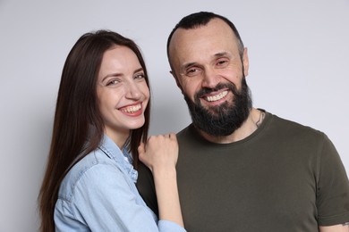 Portrait of happy daughter and father on light grey background