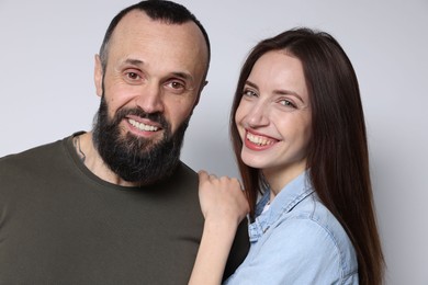 Portrait of happy daughter and father on light grey background