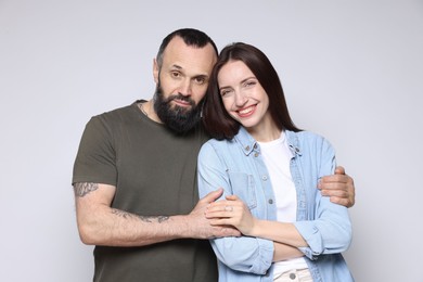 Portrait of happy daughter and father on light grey background