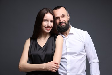 Portrait of happy daughter and father on dark grey background