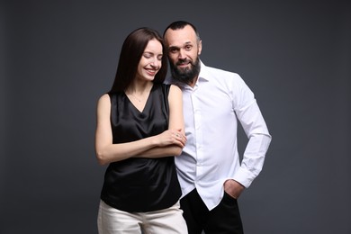 Portrait of happy daughter and father on dark grey background