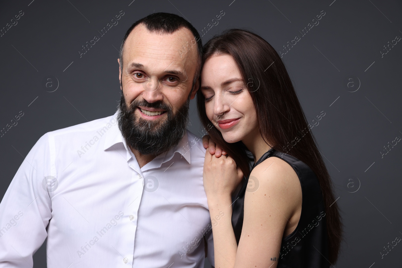 Photo of Happy daughter and father on dark grey background