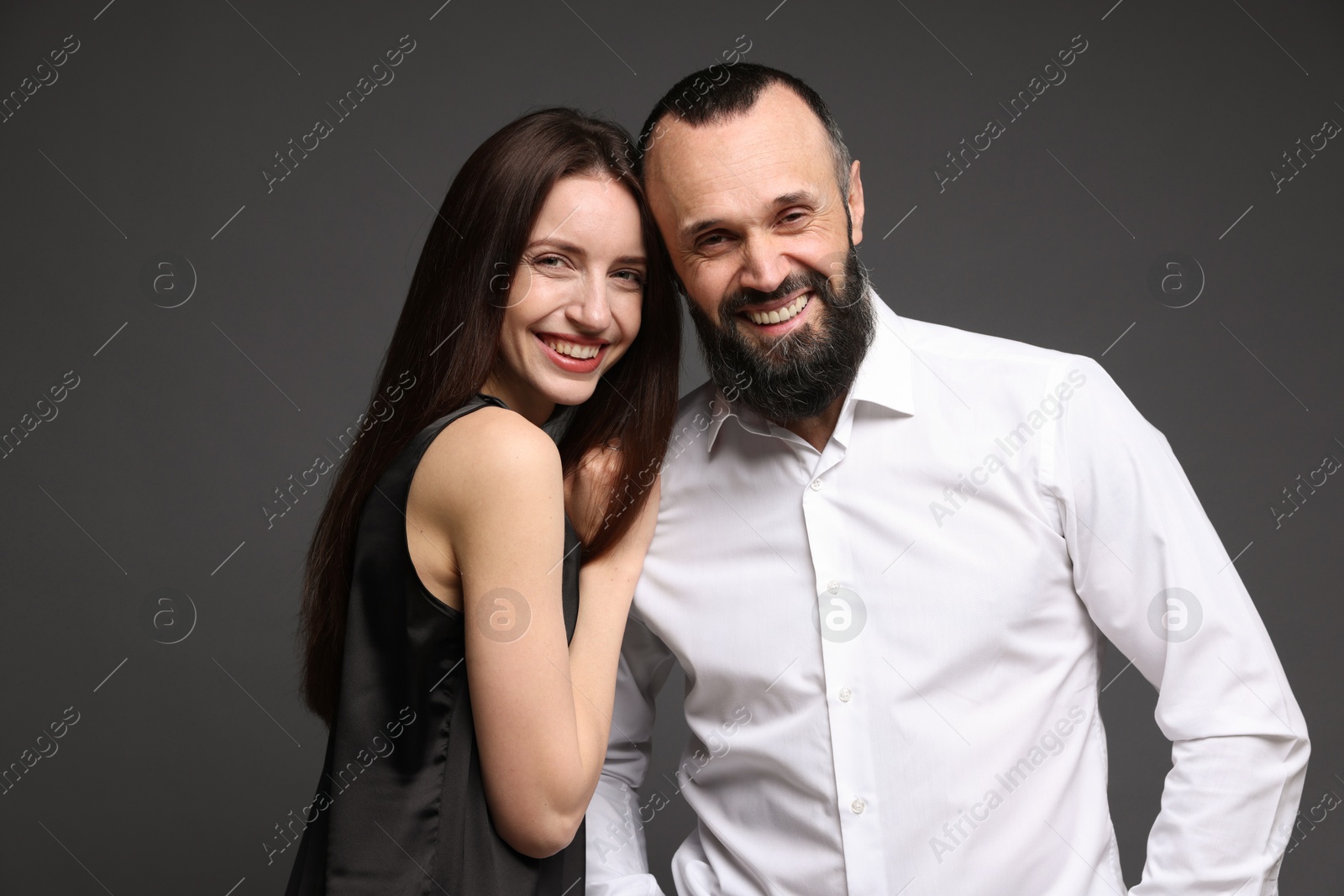 Photo of Portrait of happy daughter and father on dark grey background