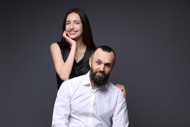 Portrait of happy daughter and father on dark grey background