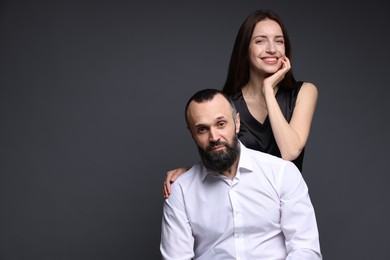 Portrait of happy daughter and father on dark grey background. Space for text