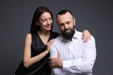 Photo of Happy daughter and father on dark grey background