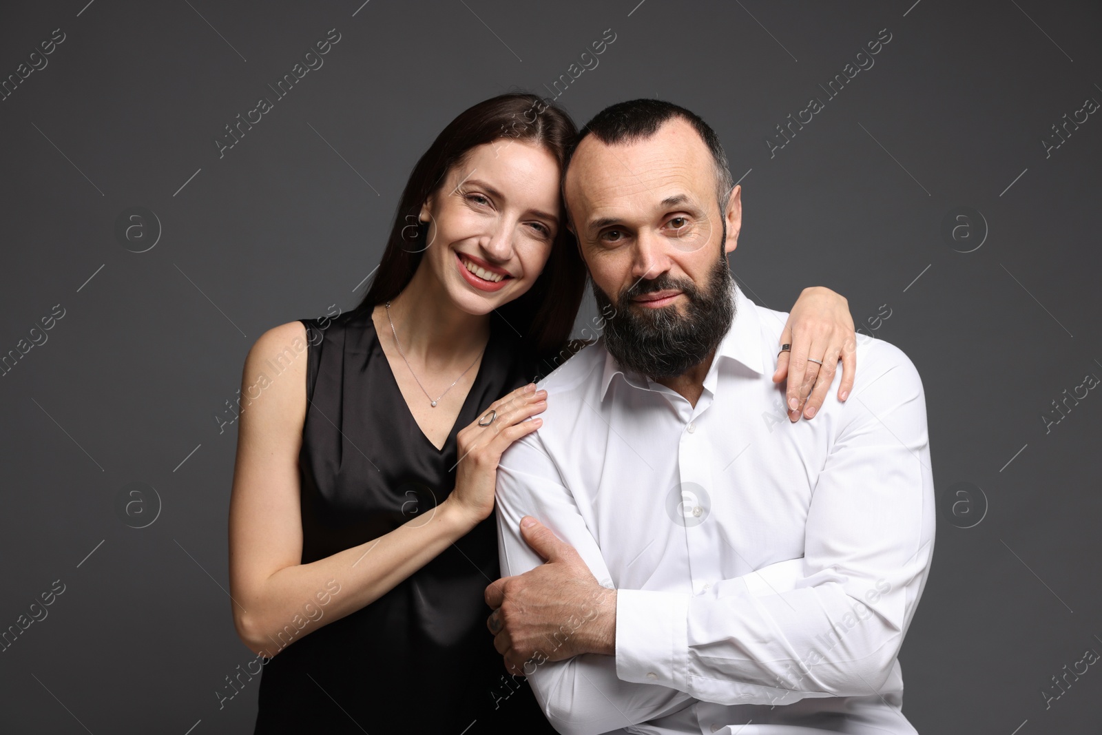 Photo of Portrait of happy daughter and father on dark grey background