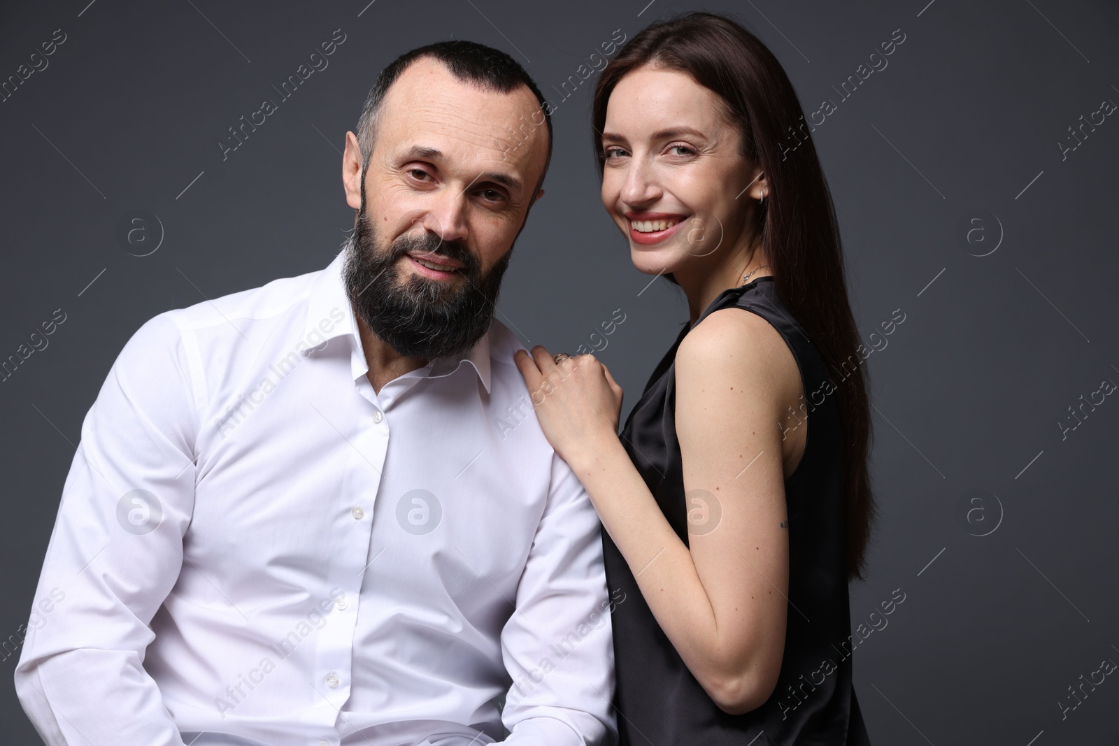 Photo of Portrait of happy daughter and father on dark grey background