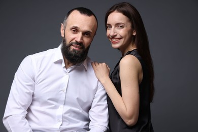 Portrait of happy daughter and father on dark grey background