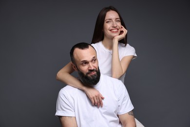 Photo of Happy daughter and father on dark grey background