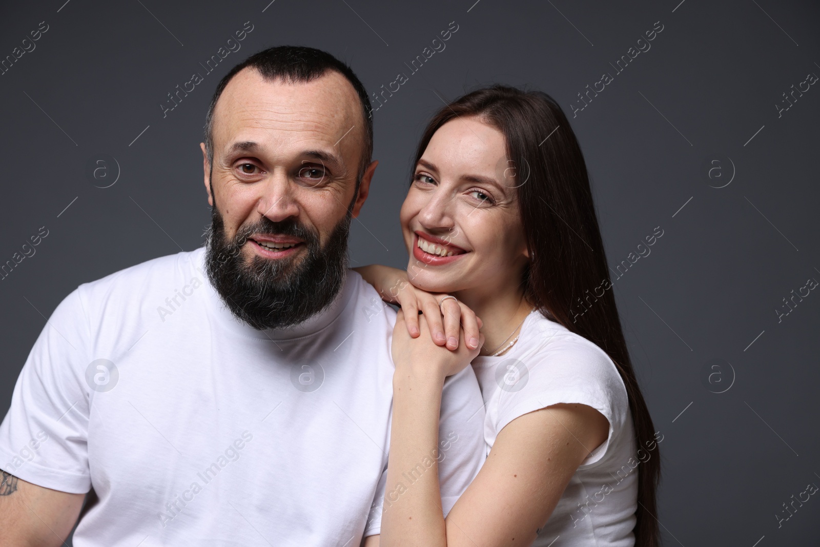 Photo of Portrait of happy daughter and father on dark grey background